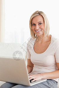 使用笔记本电脑的金发女人肖像图片