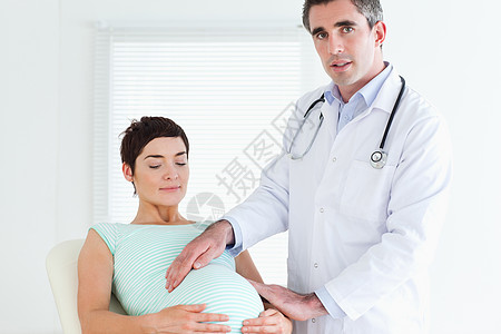 检查孕妇腹部的医生(男)图片
