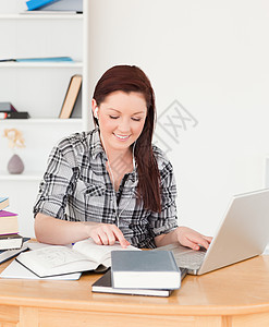 漂亮的红发美女女孩 用笔记本电脑放松图片