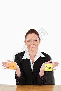 一个微笑着的女商务人士的肖像 在工作与玩耍之间被撕裂图片