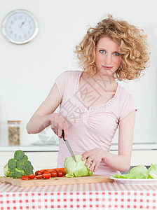 迷人的金发美女 在厨房做菜 煮蔬菜图片