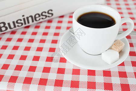 一杯咖啡和一张桌布上的报纸图片