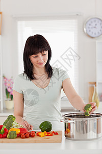 美丽的棕发美女做菜的青红色女人图片
