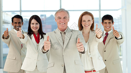 带着拇指微笑的多族裔商业团队图片