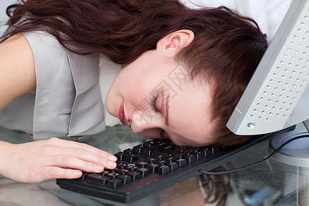 在办公室键盘上睡着的女商业家图片