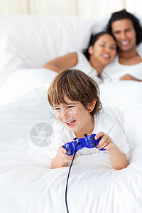 玩电子游戏的可爱小男孩孩子卧室音乐男性乐趣男人教育青年女士童年图片