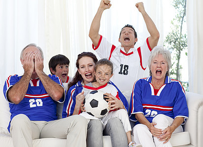 家庭在电视上看足球比赛父亲说谎祖父男人沙发男性支持者团队母亲祖父母图片