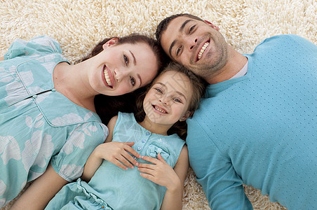 父母和女儿在地板上与头一起高高角度图片