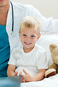 坐在医院床上的 一个微笑的小男孩的肖像图片