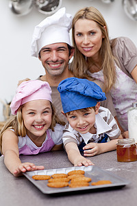 快乐的孩子和父母在烘烤后吃饼干图片