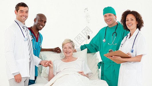 医院小组和一位女性病人在镜头前微笑图片