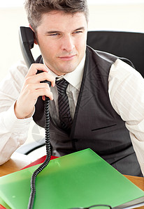 在办公室通过电话交谈的自有自信的商务人士图片