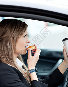 有吸引力的女商务人士吃东西 同时喝杯酒交通饮料管理人员运输驾驶法律风险车辆食物危险图片