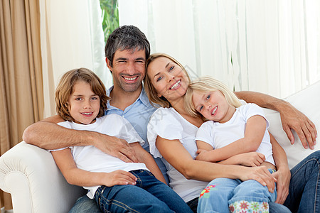 微笑的家庭在沙发上放松图片