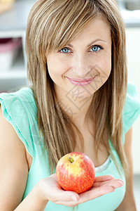 一个美丽的女人的肖像 拿着苹果看着Ca市图片