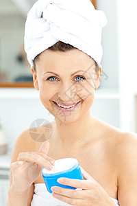 可爱的年轻女人 用毛巾 在她脸上加奶油皮肤女性广告脸颊润肤魅力洗剂浴室女孩护理图片