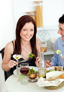微笑的年轻夫妇在厨房吃饭图片