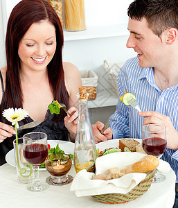 年轻caucasian夫妇在家吃晚饭图片