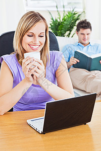 开心的女士用笔记本电脑 和她男朋友一起喝杯咖啡图片