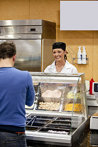 女性厨师等待学生在咖啡馆选择午餐时的女厨师图片