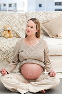 孕妇瑜伽坐在地板上做瑜伽的五肢孕妇背景