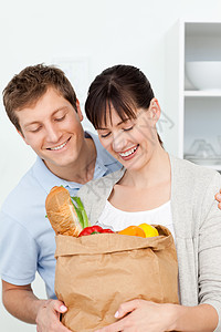 看着购物袋的一对可爱的夫妇妻子消费者店铺女孩夫妻解雇食物零售男人水果图片