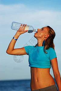 妇女饮用水成人海滩慢跑者女性练习慢跑瓶子行动日落赛跑者图片