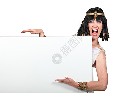 身着Cleopatra服装的妇女指向一个空白的标志图片