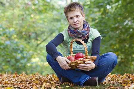 女人一篮子的红苹果花园太阳水果卫生保健女孩树叶女性乐趣食物图片