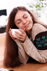 一茶一点素材年轻女人在家喝茶时要暖和一点女孩饮料享受咖啡房子毛衣女士微笑黑发快乐背景