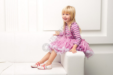 小女孩在沙发上快乐地装扮幸福拥抱喜悦女孩生活房子裙子姿势房间家庭图片