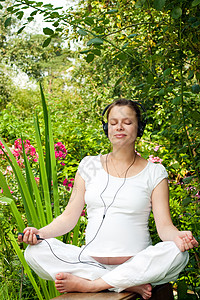 在花园里放轻松玩家黑发母亲叶子音乐腹部耳机冥想怀孕治疗图片