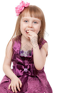 小女孩吃糖果 孤立在白种背景上图片