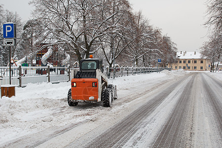 小型挖土机山猫在街上工作街道推土机运输环境雪堆打扫机械城市机器天气图片