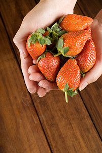 女性厨师手中的草莓饮食食物白色水果女士木头桌子素食主义者红色背景图片