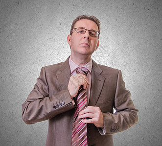 深思熟虑的商务人士把他的领带贴在白背景上套装管理人员思考眼镜思维考试男性商业经理人士图片
