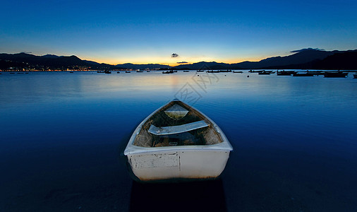 湖边的日落 船钓鱼太阳橙子假期美丽天空地平线海洋航行反射图片