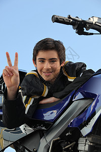 青少年站在他的摩托车旁图片