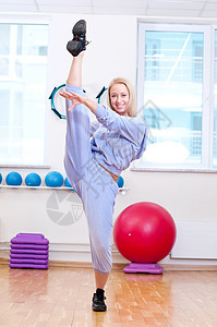 微笑的女性在体育俱乐部做伸展运动福利瑜伽火车健身房女士闲暇生活运动装培训师身体图片