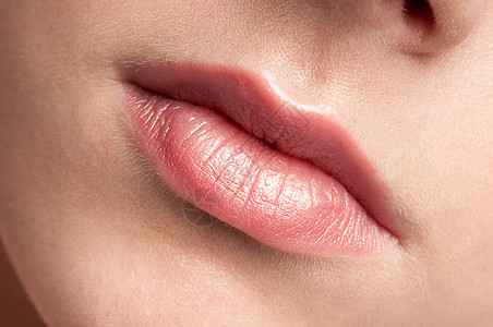 美丽年轻女子的近吻嘴唇刷子护理快乐女士鼻子牙齿女性口红化妆品画笔图片