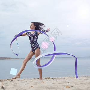 年轻体操女子与丝带跳舞跑步乐队乐趣运动员舞蹈海洋天空女性有氧运动演员图片