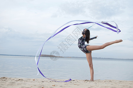 年轻体操女子与丝带跳舞活动身体天空女士有氧运动孩子幸福微笑生活海滩图片