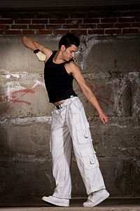 现代风格的Hip Hop男孩跳过灰砖墙运动衣服霹雳舞跳舞男人夜生活慢跑裤裤子慢跑鞋青少年图片