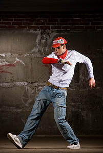 现代风格的Hip Hop男孩跳过灰砖墙锻炼运动鞋姿势牛仔裤青少年培训师男人男生有氧运动裤子图片