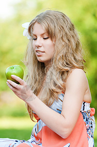 美丽的绿苹果女美人野餐女士阳光女孩饮食食物头发草地手指享受图片