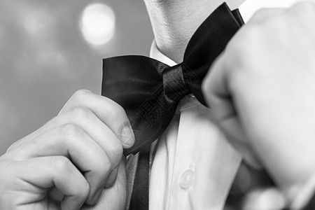 男人的手触摸着领结主持人衣领领带裁缝袖子纺织品夹克燕尾服新郎工作室图片