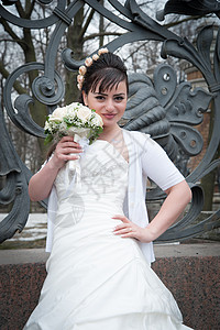 公园栅栏上带花束的新娘成人魅力白色幸福婚礼微笑裙子图片