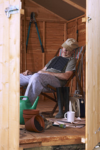 睡在棚子里家庭生活靴子午休木头工具躺椅报纸孤独收音机金融图片