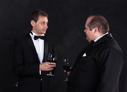 两个时髦的商务人士 穿着晚礼服 戴红酒眼镜正装男性商务男人衣服躯干服务员领结纽扣奢华图片