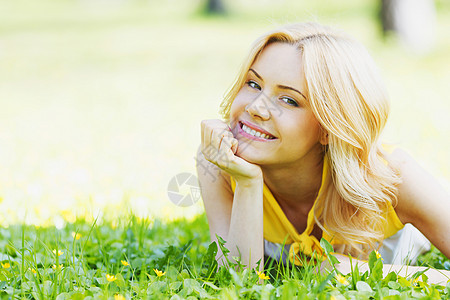 女人躺在草地上女孩成人微笑自由快乐公园金发黄色说谎喜悦图片